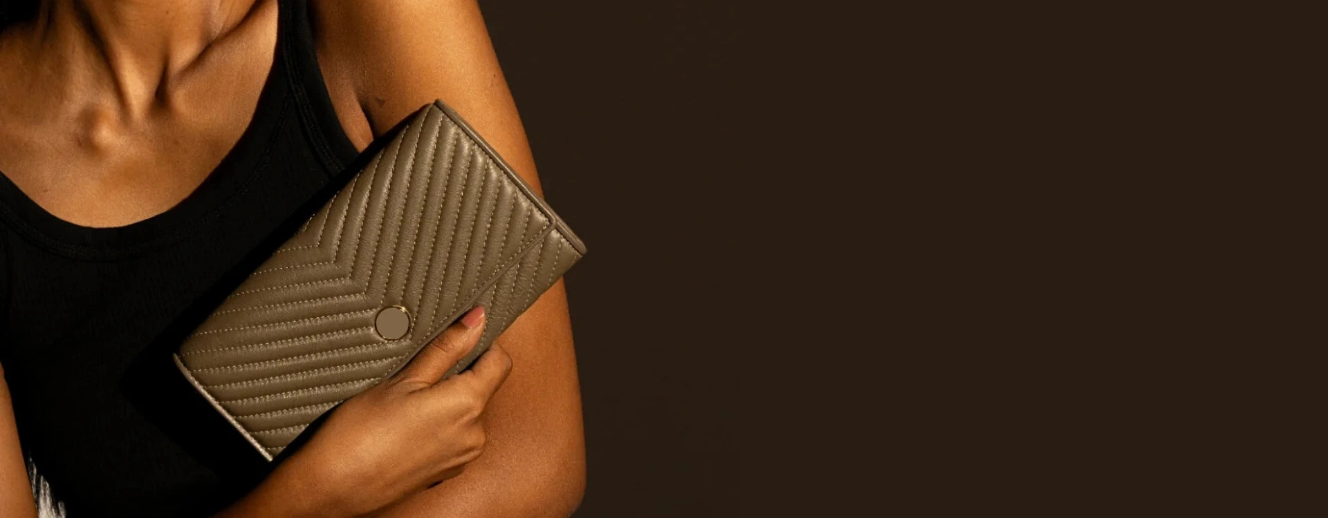 Person holding a textured wallet against a dark background